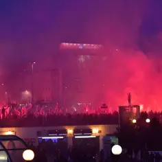 Tłum z polskimi flagami i racami na tle nocnego miasta. Widać billboard Santander. Manifestacja, która może być wyrazem etnocentryzmu.