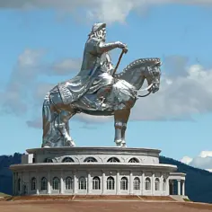 Gigantyczny pomnik Czyngis-chana na koniu, symbol potęgi imperium mongolskiego, góruje nad krajobrazem.