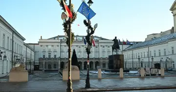 Pałac Prezydencki w Warszawie, z pomnikiem konnym i flagami, symbolizuje stabilność i ciągłość władzy, przypominając o kadencji prezydenta.