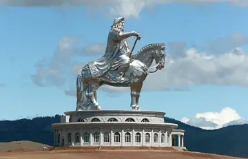 Gigantyczny pomnik Czyngis-chana na koniu, symbol potęgi imperium mongolskiego, góruje nad krajobrazem.